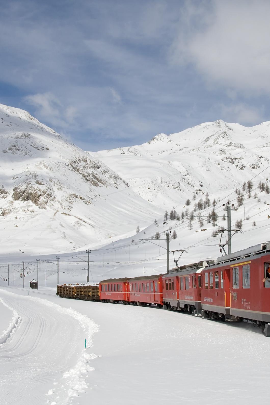 Trein rijd door de besneeuwde bergen