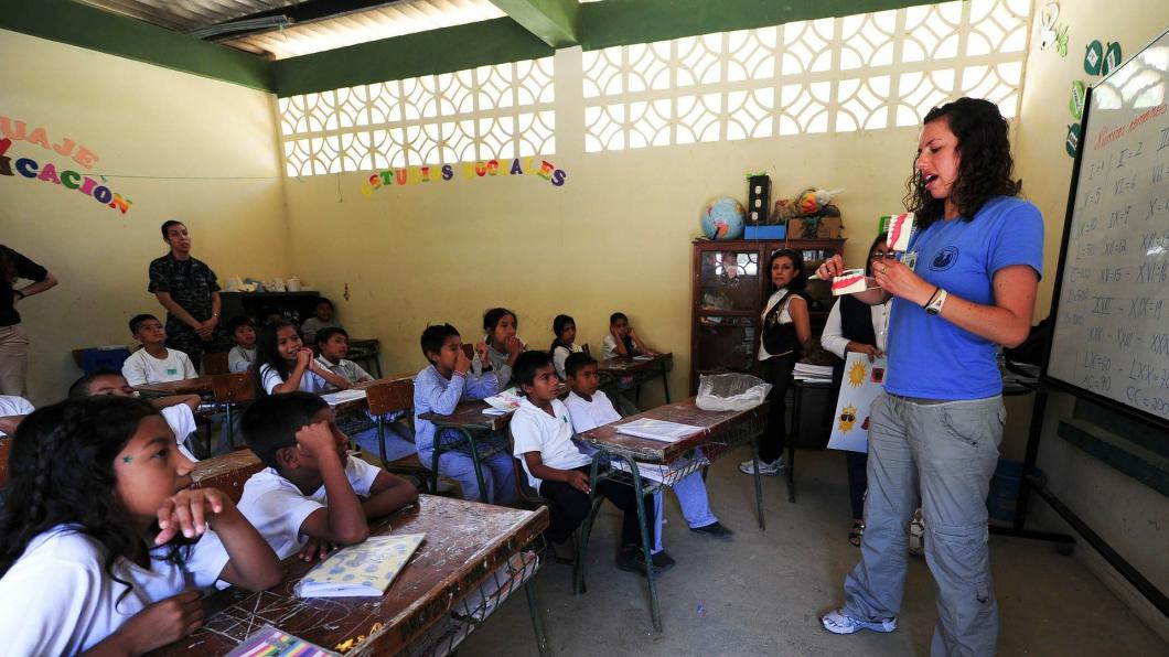 Een lerares staat voor een basisschoolklas in een Zuid-Amerikaans land