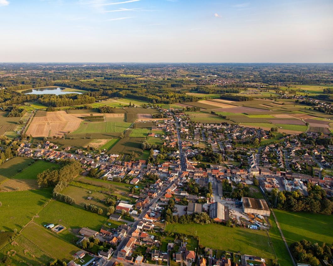 Luchtfoto van een Nederlands dorp met akkers er omheen