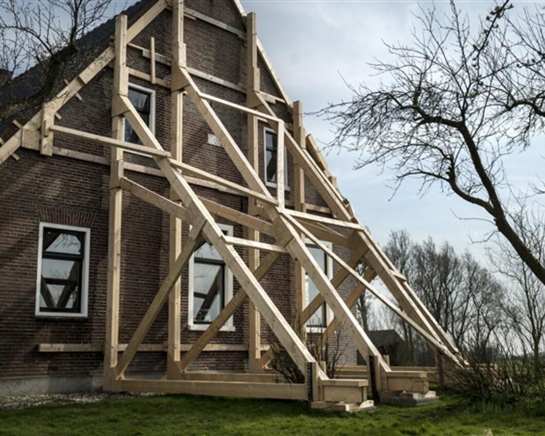 Huis in Groningen wordt ondersteund na aardbevingschade.