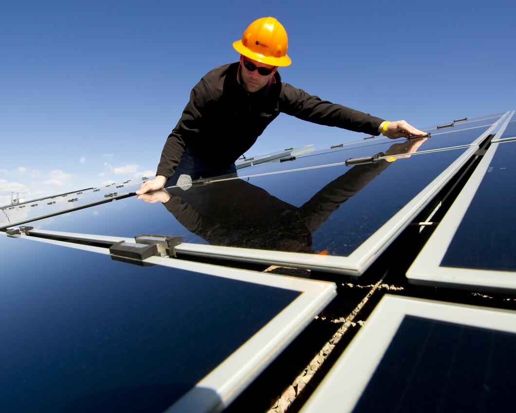 Een man installeert zonnepanelen