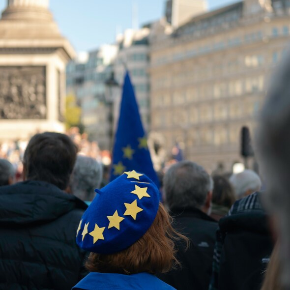 Foto van persoon met een hoofddeksel in de kleuren van de Europese vlag