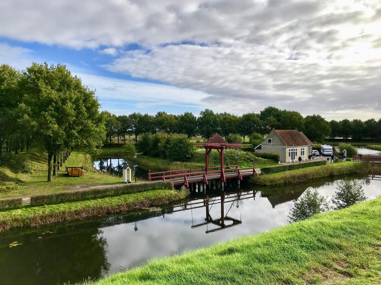 Een rode ophaalbrug over het water bij vestiging Bourtange te Groningen.